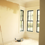 Interior of a Charleston home being painted in autumn light with tall paned windows